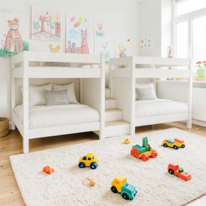 Könnte beinhalten: Helles Kinderzimmer mit zwei weißen Etagenbetten, weißer Bettwäsche und dekorativen Kissen. Bunte Kinderkunstwerke schmücken die Wände. Der Raum ist mit einem flauschigen weißen Teppich und Spielzeugautos dekoriert.
