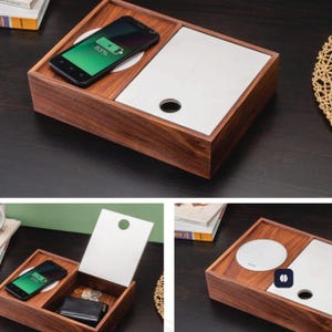 May include: A wooden charging station with a built-in wireless charger and a storage compartment. The station has a dark brown finish and a white charging pad. A smartphone is placed on the charging pad, displaying a charging icon and battery percentage.