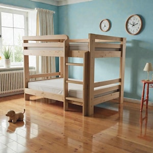 May include: A light-colored wooden bunk bed with a ladder, set against a light blue wall. The bed has two levels with mattresses. A small toy dog sits on the wooden floor. Two clocks hang on the wall.