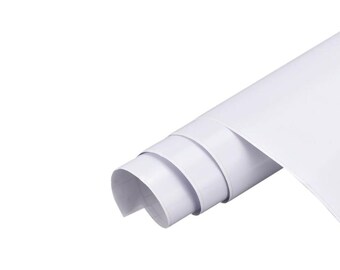 Könnte beinhalten: Eine Rolle aus glattem, undurchsichtigem weißem Material, das teilweise ausgerollt ist. Das Material hat eine saubere, einfarbig weiße Oberfläche mit leichtem Glanz und ist in mehreren Schichten zu einer zylindrischen Form aufgerollt.