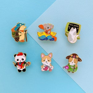 May include: A collection of enamel pins featuring adorable animal characters. Includes a hedgehog with a backpack, a koala in a boat, a cat with a computer, a panda with a paintbrush, a corgi knitting, and a dog with a watering can.
