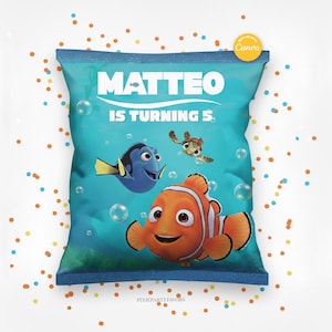 Puede incluir: Una bolsa de fiesta turquesa con el texto "MATTEO IS TURNING 5" e ilustraciones de Dory, Nemo y Crush de la película Buscando a Nemo. La bolsa tiene un borde azul y está decorada con burbujas.