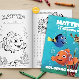 May include: A coloring book and open page with a black and white illustration of a clownfish, with the text "MATTEO IS TURNING 5". The cover features Nemo, Dory, and Crush, with the text "COLORING BOOK". Crayons are scattered around.