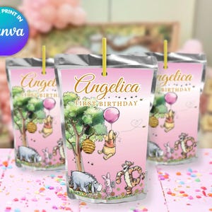May include: Pink and silver juice box labels featuring Winnie the Pooh characters and the text "Angelica First Birthday".
