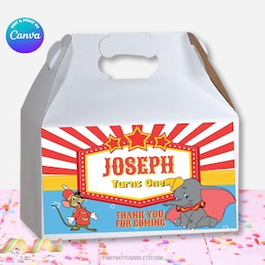 Puede incluir: Caja blanca con diseño de circo. La caja presenta rayas rojas y blancas, estrellas y el texto "JOSEPH Turns One". También hay ilustraciones de Dumbo el elefante y un ratón. Se incluye el texto "THANK YOU FOR COMING".