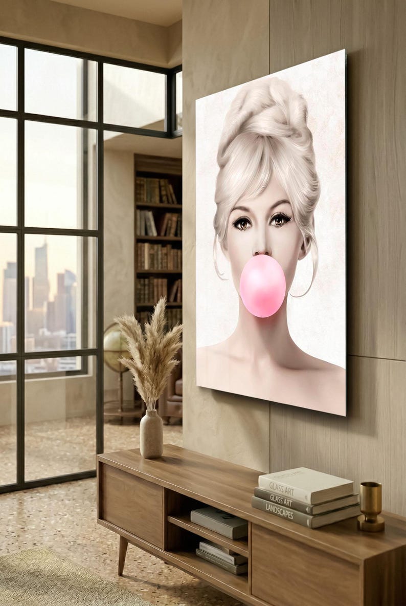May include: A canvas print featuring a woman with blonde hair and a pink bubble gum bubble. The artwork has a vintage aesthetic, with the woman's face as the focal point. The background is a neutral color, and the image is displayed in a modern interior.