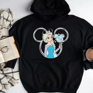 Puede incluir: Sudadera con capucha negra con una silueta blanca de Mickey Mouse que presenta una imagen de dibujos animados de Elsa de Frozen sosteniendo un algod&oacute;n de az&uacute;car azul y blanco.