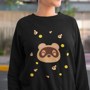May include: Black sweatshirt with a brown cartoon animal face and yellow and brown star-shaped designs.