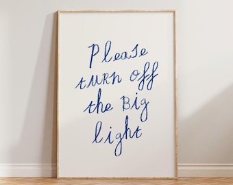 May include: A white framed print with blue handwritten text that reads "Please turn off the big light".