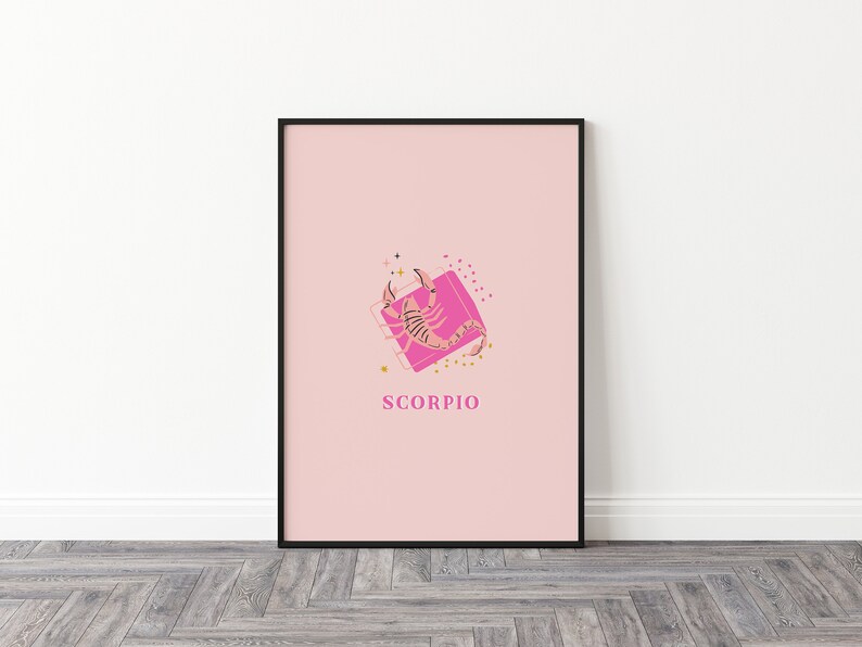 May include: A framed wall art print featuring a light pink background with a central graphic of a scorpion in shades of brown and black. The scorpion is positioned over a bright pink square with gold star and dot accents. The text SCORPIO is below.