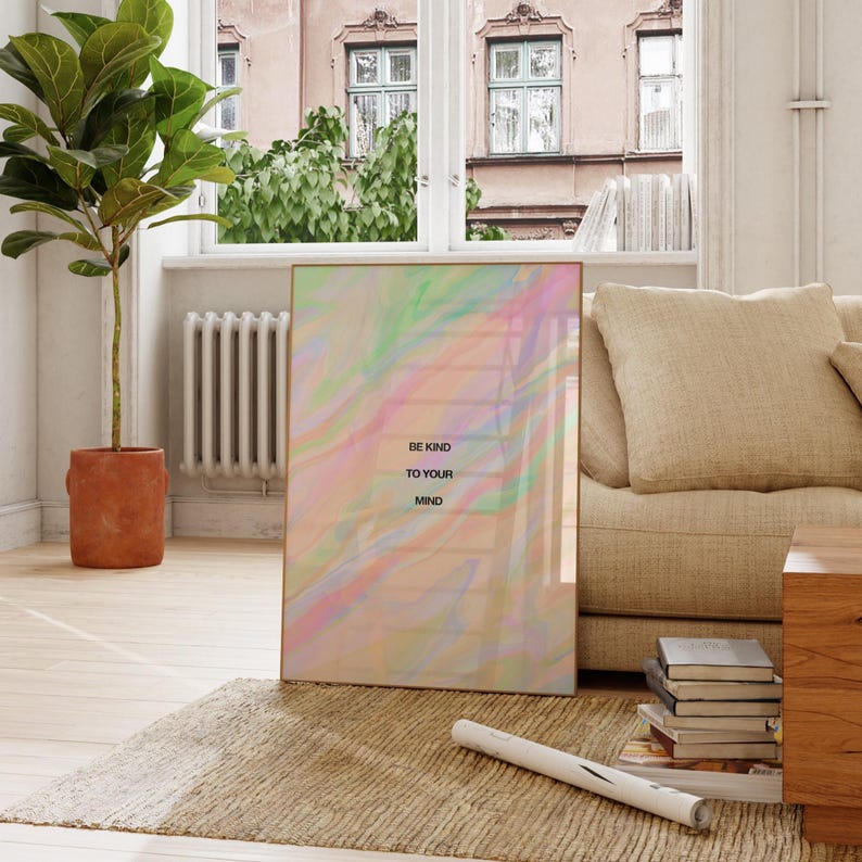 May include: A framed art print with a pastel, swirled design in shades of pink, green, and yellow. The text "BE KIND TO YOUR MIND" is printed in black. The artwork is displayed in a living room setting.