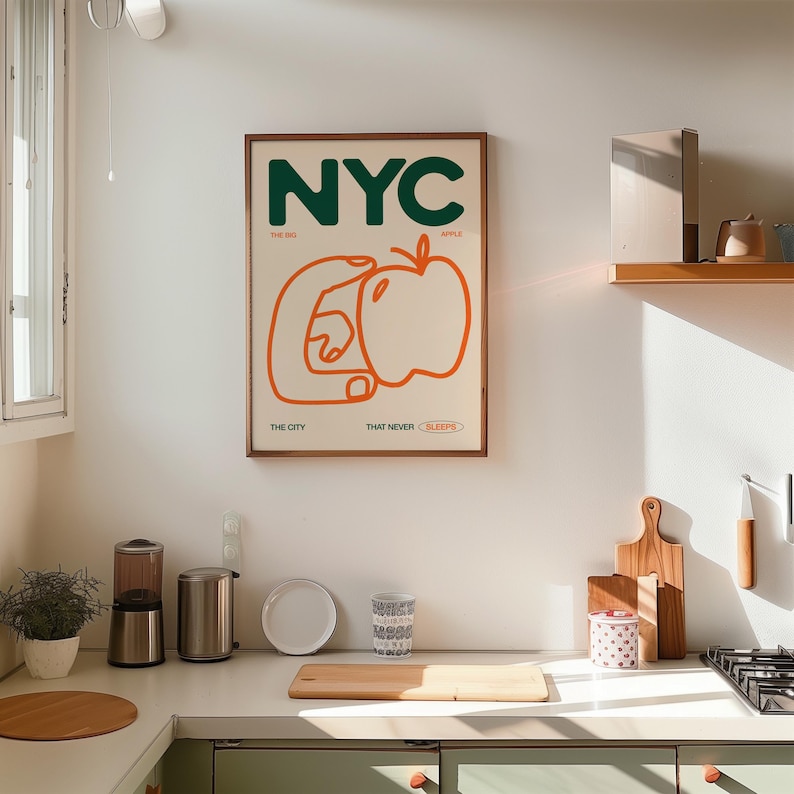 May include: A framed print with the text "NYC" in green letters, with the words "The Big Apple" and "The City That Never Sleeps" below. The print features a stylized orange hand holding a red apple.