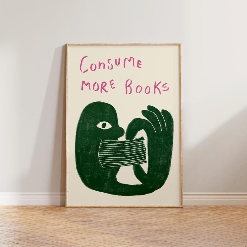 May include: A green illustration of a person with a large mouth consuming a stack of books. The text "CONSUME MORE BOOKS" is written in pink above the illustration.