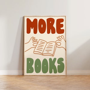 Peut inclure: Une affiche encadr&eacute;e avec le texte "MORE BOOKS" en lettres rouges et vertes. L'affiche pr&eacute;sente une image de dessin anim&eacute; de deux mains tenant un livre ouvert.