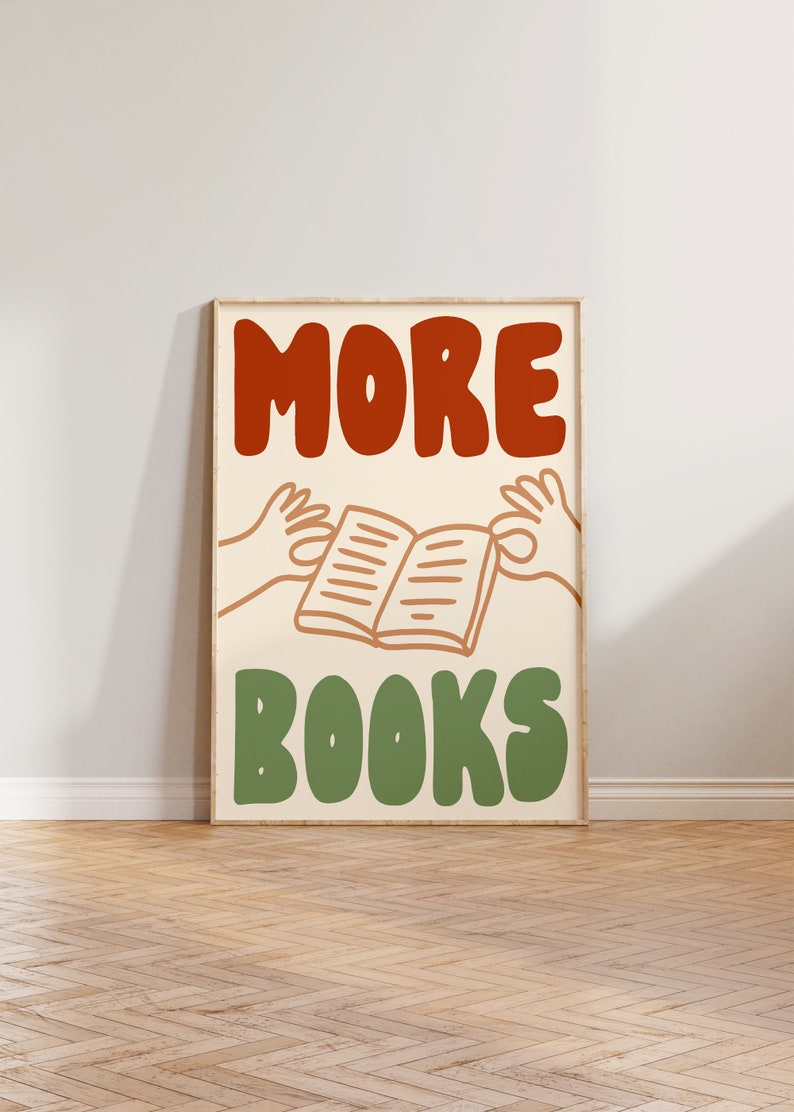 Peut inclure: Une affiche encadr&eacute;e avec le texte "MORE BOOKS" en lettres rouges et vertes. L'affiche pr&eacute;sente une image de dessin anim&eacute; de deux mains tenant un livre ouvert.