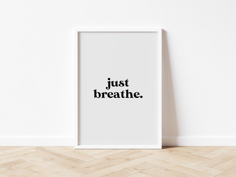 May include: White framed print with the text "just breathe." on a light gray background.