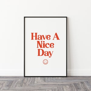 May include: A black framed print with a white background and red text that says "Have A Nice Day" with a red smiley face below the text.
