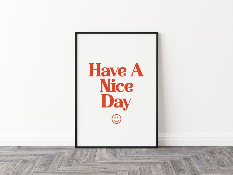 May include: A black framed print with a white background and red text that says "Have A Nice Day" with a red smiley face below the text.