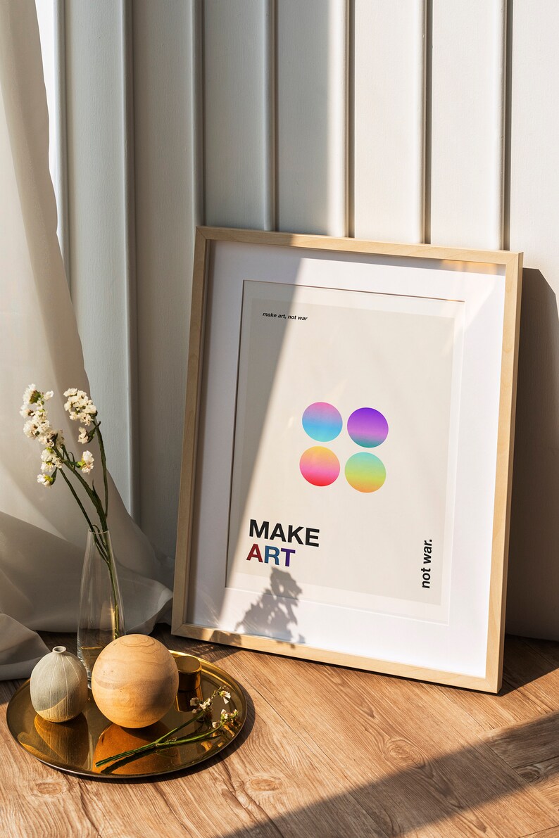 Pode incluir: Um p&ocirc;ster emoldurado com fundo branco e c&iacute;rculos coloridos. O p&ocirc;ster diz "MAKE ART not war."
