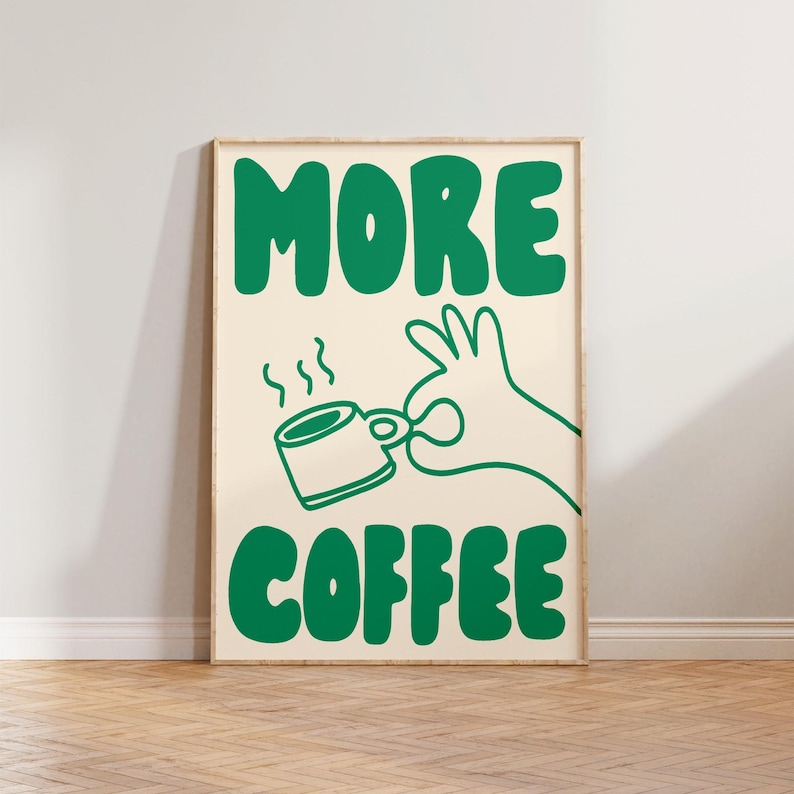 May include: A green and white poster with the text "MORE COFFEE" in a bold, cartoon font. A green cartoon hand is holding a green coffee cup with steam coming from it.
