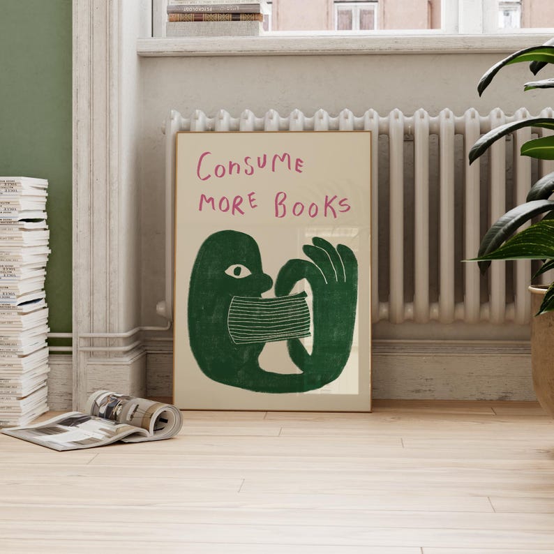 May include: A green illustration of a person consuming a book with the text "Consume More Books" in pink lettering.