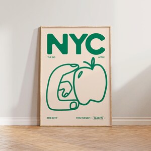 May include: A green and white poster with the text "NYC" in large green letters. The poster also includes a green outline of a hand holding an apple with the text "THE BIG APPLE" below. The text "THE CITY THAT NEVER SLEEPS" is at the bottom of the poster.