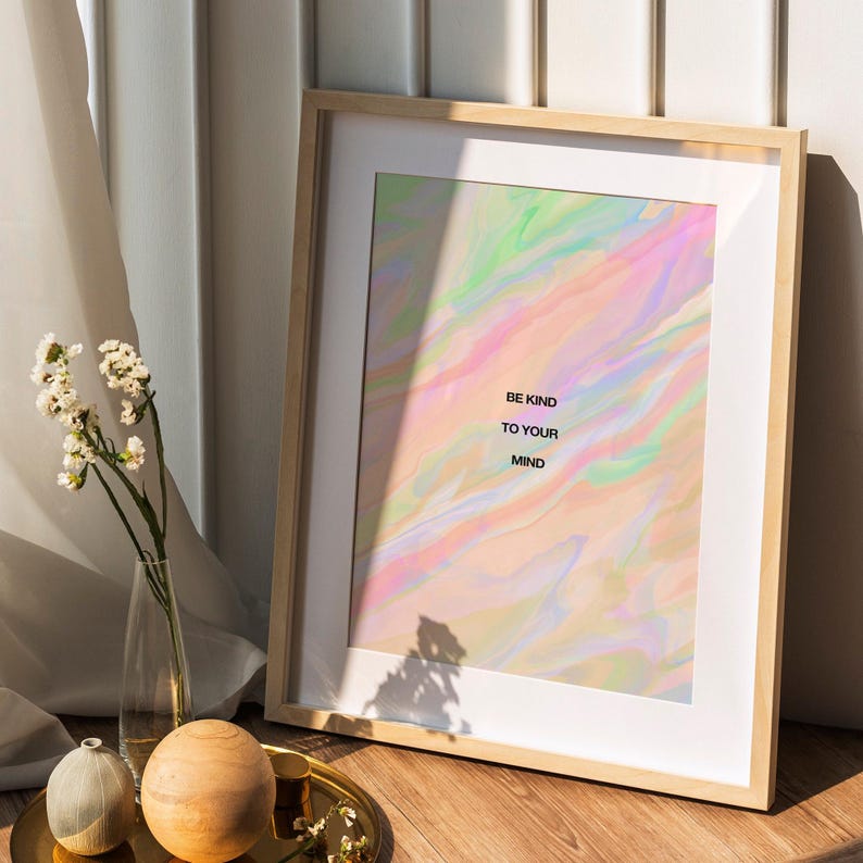 May include: Framed art print with a pastel abstract design in shades of pink, green, and blue. The print features the text "BE KIND TO YOUR MIND" in a minimalist font. The frame is made of light-colored wood.