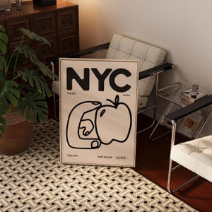 May include: A black and white poster with the text "NYC" in large bold letters. The poster also includes the text "The Big Apple, The City That Never Sleeps" and a graphic of a hand holding an apple.