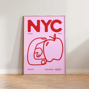 May include: A pink and red poster with the text "NYC" in large red letters. The text "THE BIG APPLE" is below the letters. A red hand is holding a red apple. The text "THE CITY THAT NEVER SLEEPS" is at the bottom of the poster.