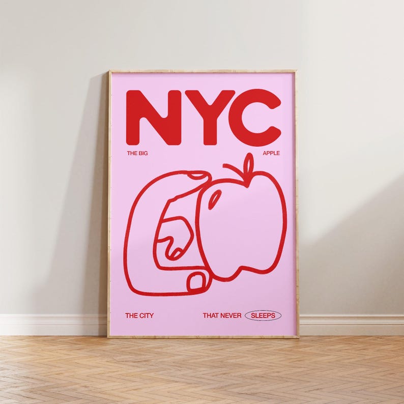 May include: A pink and red poster with the text "NYC" in large red letters. The text "THE BIG APPLE" is below the letters. A red hand is holding a red apple. The text "THE CITY THAT NEVER SLEEPS" is at the bottom of the poster.