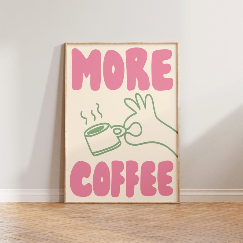 May include: A pink and green illustration of a hand holding a coffee cup with steam coming from it. The text "MORE COFFEE" is written in pink letters.