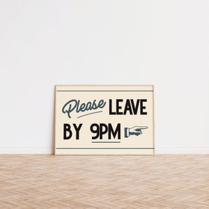 May include: A framed rectangular sign with the text "Please LEAVE BY 9PM" in a vintage style. The words are in black and teal, with a pointing hand graphic. The sign is on a light beige background.