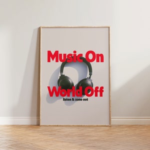 Può includere: Un poster incorniciato con il testo "Music On World Off" in lettere rosse. Il poster presenta un paio di cuffie nere su uno sfondo bianco.