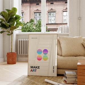Pode incluir: Um p&ocirc;ster bege com o texto "MAKE ART not war" e quatro c&iacute;rculos coloridos. O p&ocirc;ster est&aacute; pendurado em uma parede de uma sala de estar com um sof&aacute; bege e uma mesa de centro de madeira.