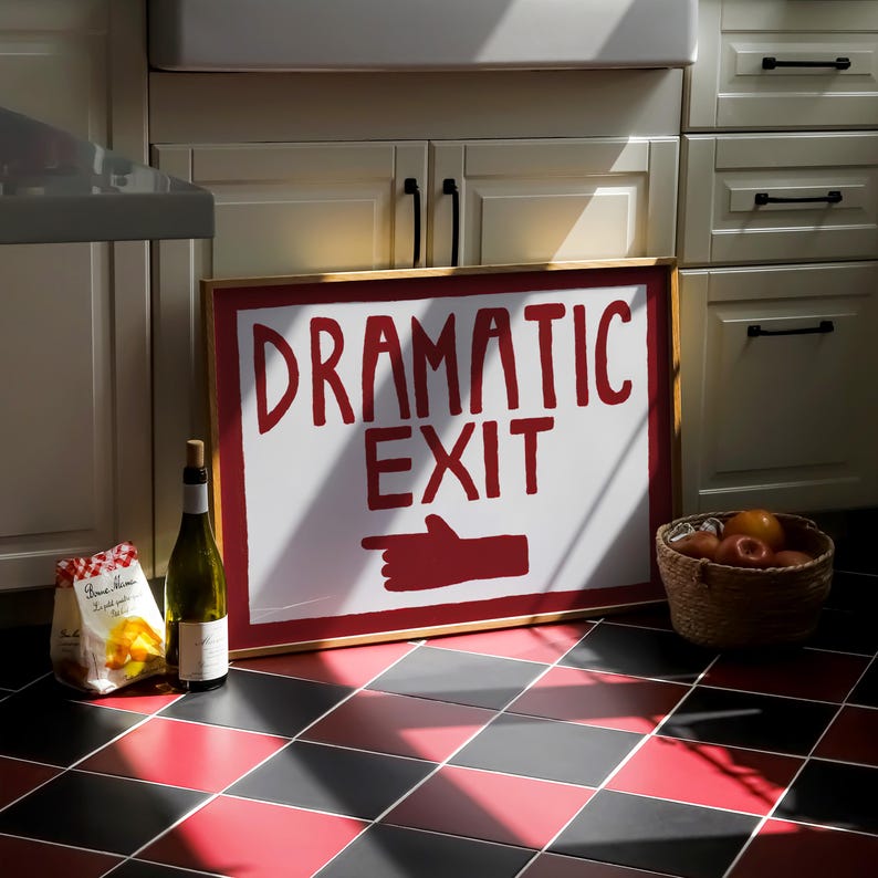 Puede incluir: Un cartel rojo y blanco con el texto "Dramatic Exit" y una mano roja apuntando hacia la derecha. El cartel est&aacute; colgado en una pared con armarios blancos y un lavabo blanco.
