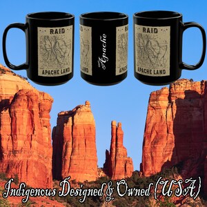 May include: Three black ceramic mugs with a map design and the words "RAID" and "APACHE LAND". One mug has the word "Apache" in script. The background features red rock formations and the text "Indigenous Designed & Owned (USA)".