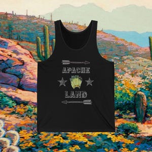 May include: Black tank top with a white graphic design that says "Apache Land" with a Native American headdress and two stars.