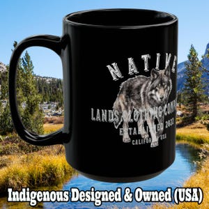 May include: Black ceramic mug featuring a detailed illustration of a wolf. The mug has the text "NATIVE LANDS CLOTHING COMPANY ESTABLISHED 2022 CALIFORNIA USA" and "Indigenous Designed & Owned (USA)" printed on it.