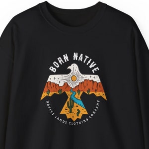 May include: Black sweatshirt with a graphic print of a stylized eagle with a sunset and desert landscape. The text "Born Native Native Lands Clothing Company" is printed around the eagle.