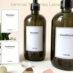 May include: Two brown glass bottles with pumps, labeled "Shampoo" and "Conditioner" with white labels and black text. The labels also include the text "Fresh Edit".