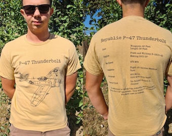 May include: Mustard-colored t-shirt featuring a detailed illustration of a P-47 Thunderbolt aircraft. The front of the shirt displays the text "P-47 Thunderbolt". The back of the shirt has technical specifications.