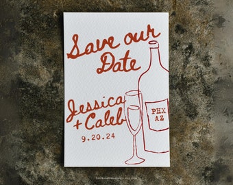Puede incluir: Tarjeta de guardar la fecha con una ilustración dibujada a mano de una botella de vino y dos copas. El texto dice "Save our Date" en cursiva, seguido de "Jessica + Caleb" y "9.20.24". La esquina inferior derecha de la tarjeta dice "PHX AZ".