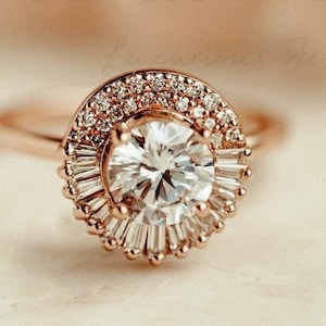 Może przedstawiać: Złoty pierścionek zaręczynowy z dużym, okrągłym diamentem centralnym otoczonym halo mniejszych diamentów i większym halo diamentów bagietkowych.