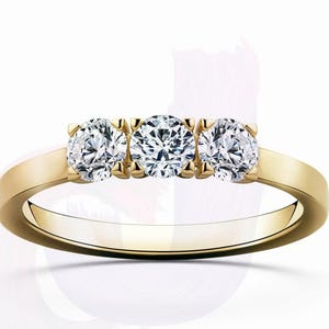 May include: A gold band ring with three round diamonds set in a row.