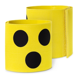 Puede incluir: Dos brazaletes de tela amarilla con puntos negros. Los brazaletes tienen cierre de velcro.