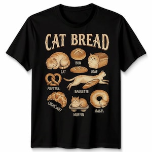 May include: Black t-shirt with the text "CAT BREAD" in a vintage font. The shirt features illustrations of cats shaped like various types of bread, including a loaf, pretzel, and croissant. A fun and whimsical design.