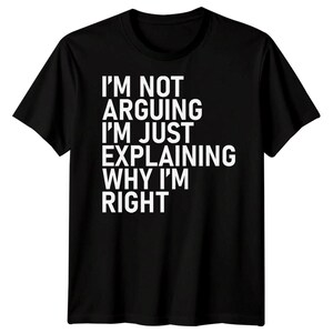 May include: Black t-shirt with white text: "I'M NOT ARGUING I'M JUST EXPLAINING WHY I'M RIGHT." The short-sleeved, crew-neck shirt has the text centred on the front. A casual garment for everyday wear.
