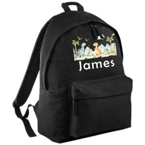 May include: Black backpack with a front pocket and a top handle. The front displays a colourful illustration of dinosaurs and the name "James" in white. The design includes palm trees, mountains, and various dinosaurs in green, orange, and blue.