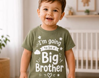 May include: An olive green short-sleeved t-shirt featuring white screen-printed text that reads I'm going to be a Big Brother. The design includes graphic elements such as stars, a small cloud, and a heart, all centered on the front of the shirt.