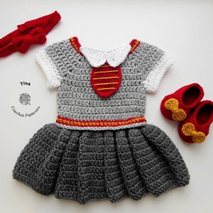 May include: A gray crocheted dress with red and gold accents, a red headband, and red shoes with gold bows. The dress has a white collar and a red and gold stripe design on the bodice. "Tina Crochet Patterns" is written on the bottom left corner of the image.